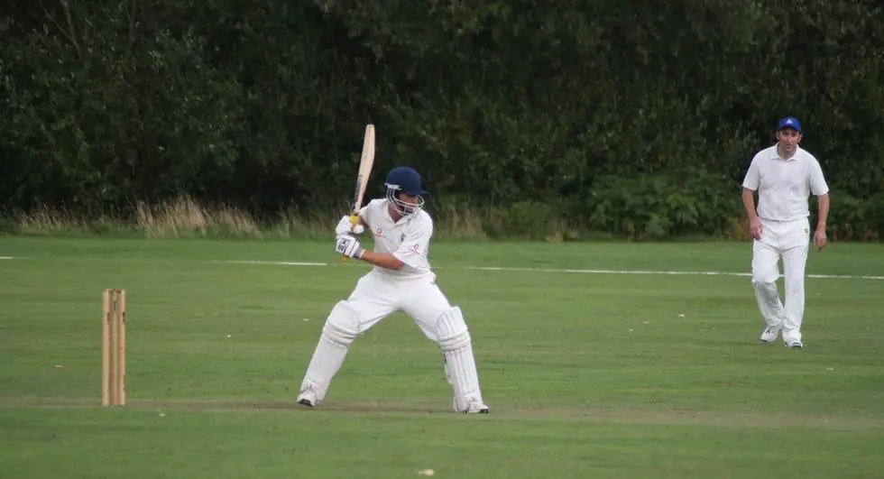 A Swyncombe batsman at the crease, bat raised, waiting on the bowler