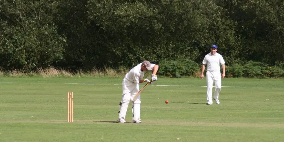 A Swyncombe batsman playing a watchful defensive shot, the ball just in front of the bat