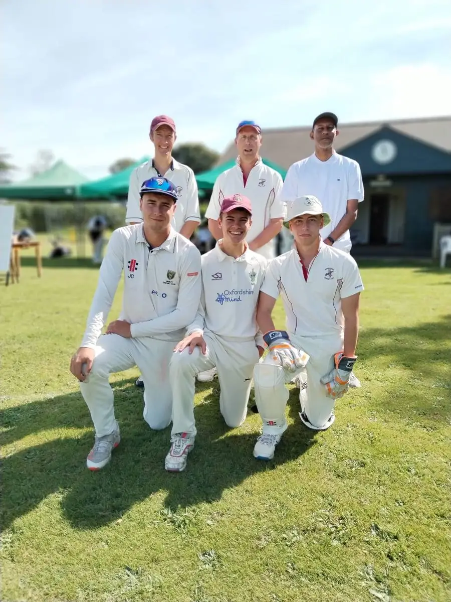 Six Swyncombe players posing in two rows in front of the pavilion