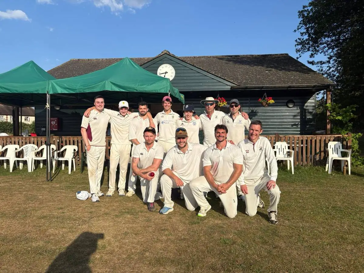 The full Swyncombe side lined up in front of the pavilion and gazebos on a sunny match day