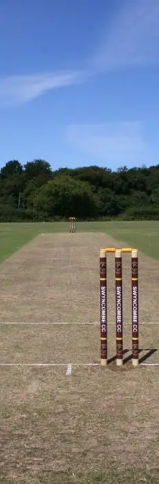 Looking down the full length of the wicket at the Field of Dreams, Swyncombe CC's maroon stumps in the foreground
